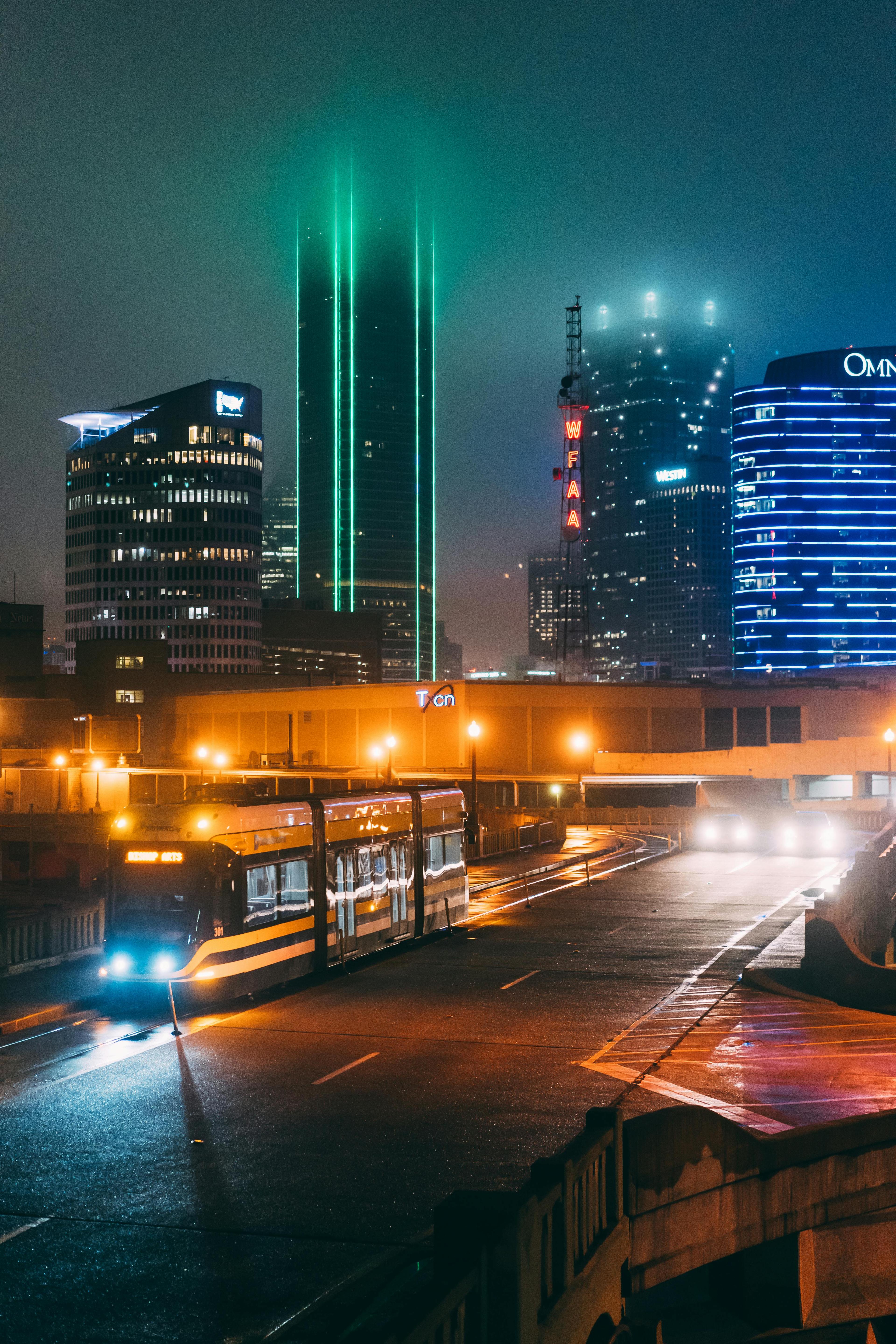 Vibrant Dallas cityscape at night featuring illuminated skyscrapers and busy urban streets.