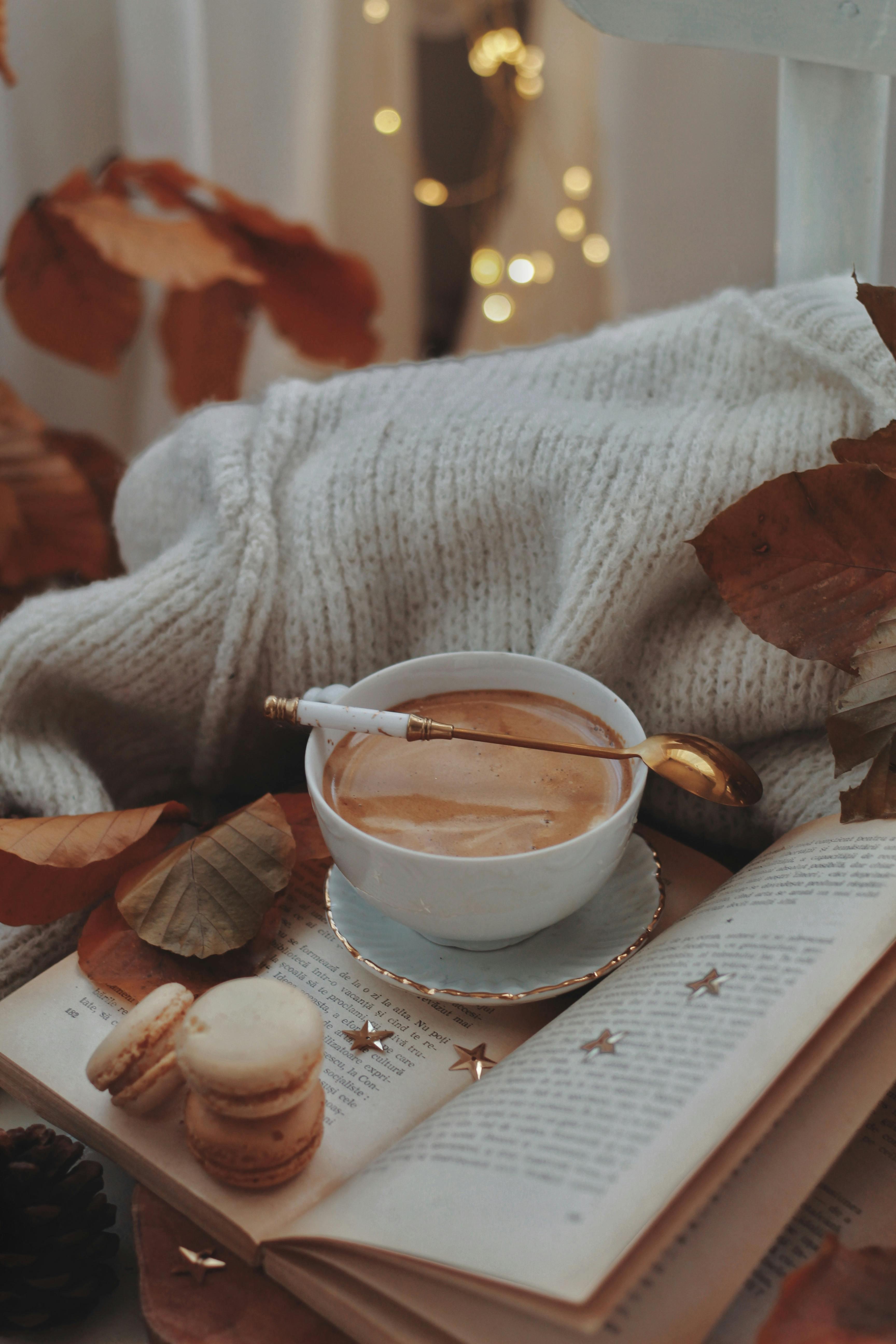 Warm autumn setting with coffee, macarons, and cozy knitwear.