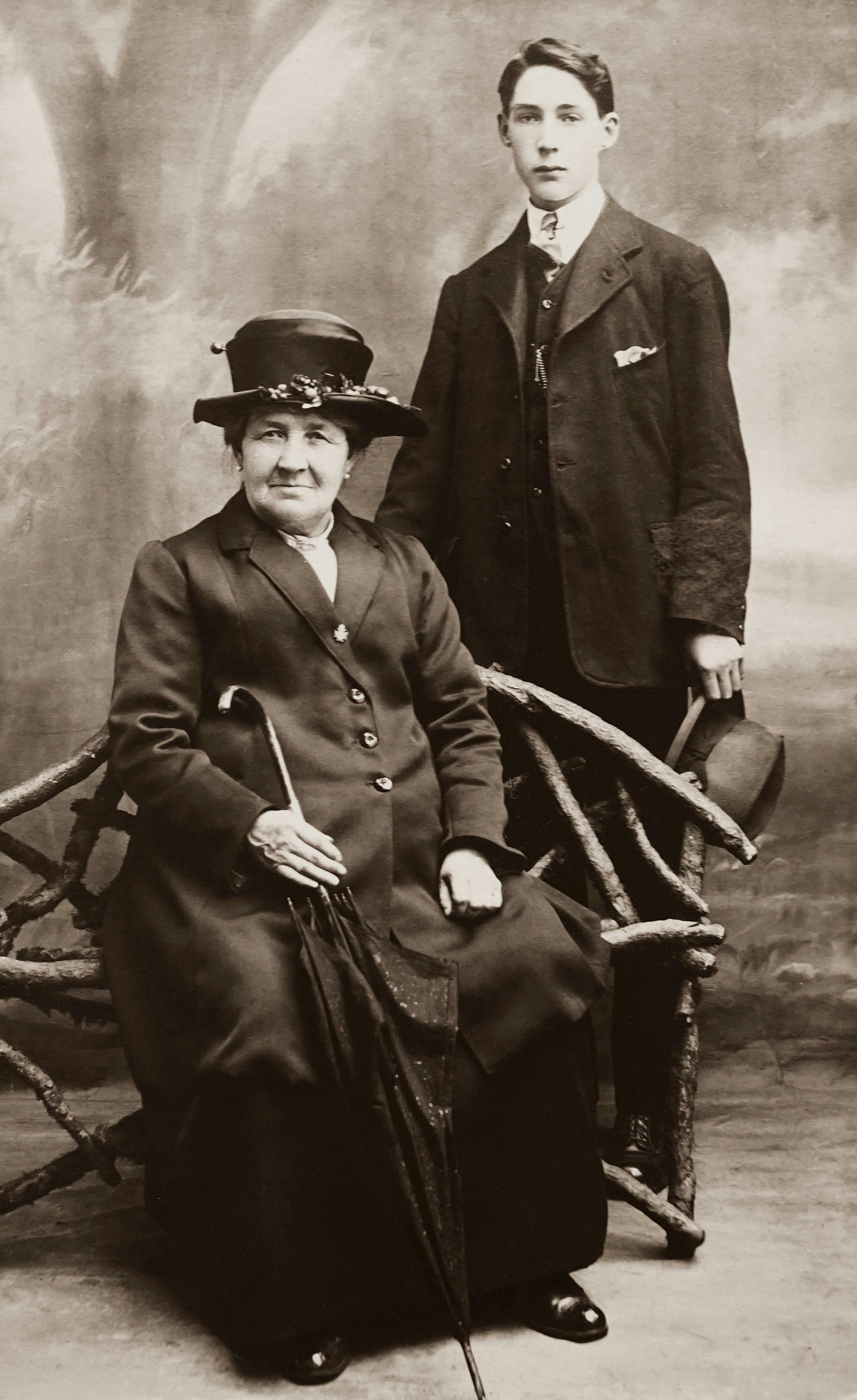 Man in Suit Standing Behind Sitting Woman Holding Umbrella