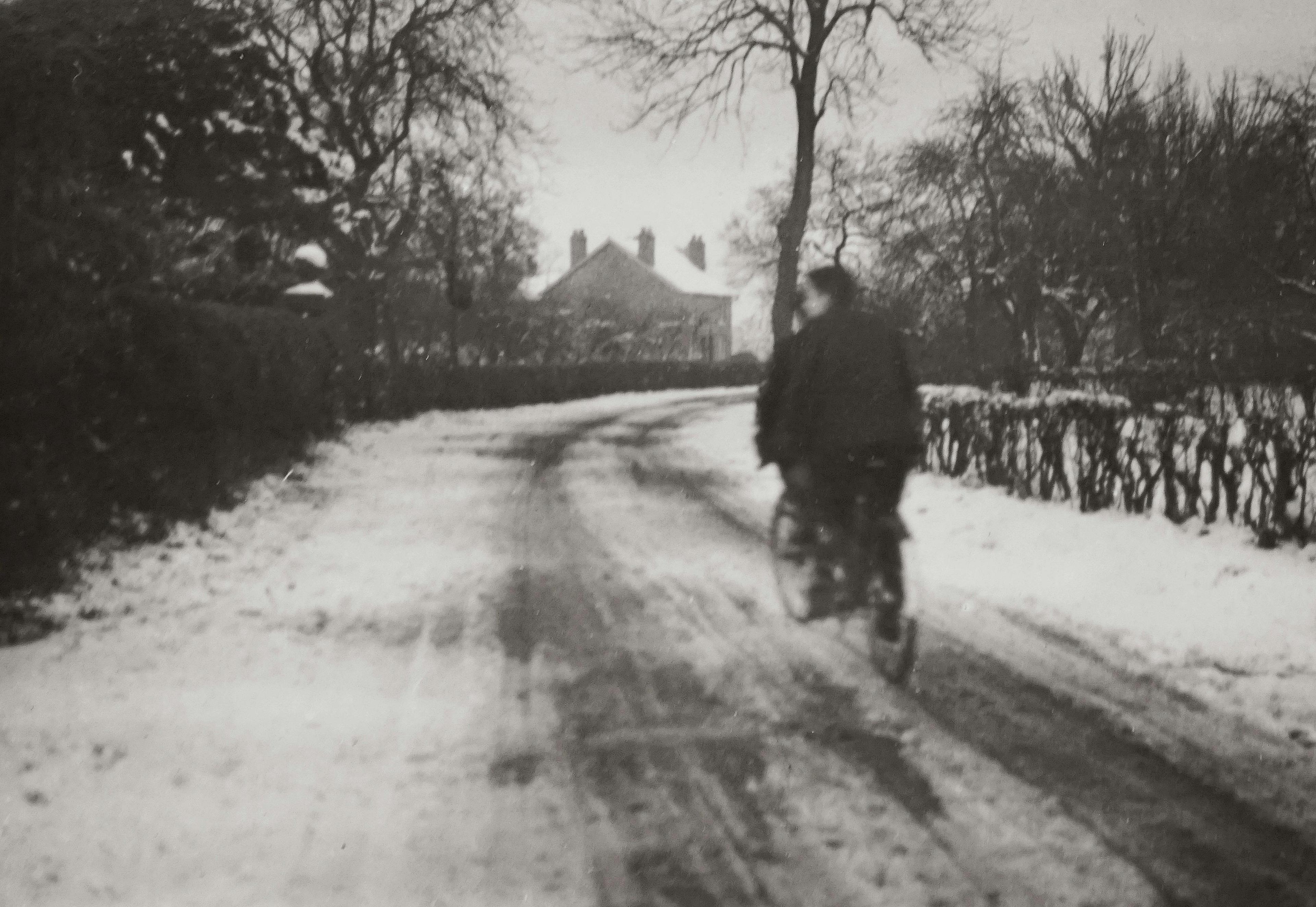 Grayscale Photography of Boys Riding a Bicycle On A Snow Covered Road