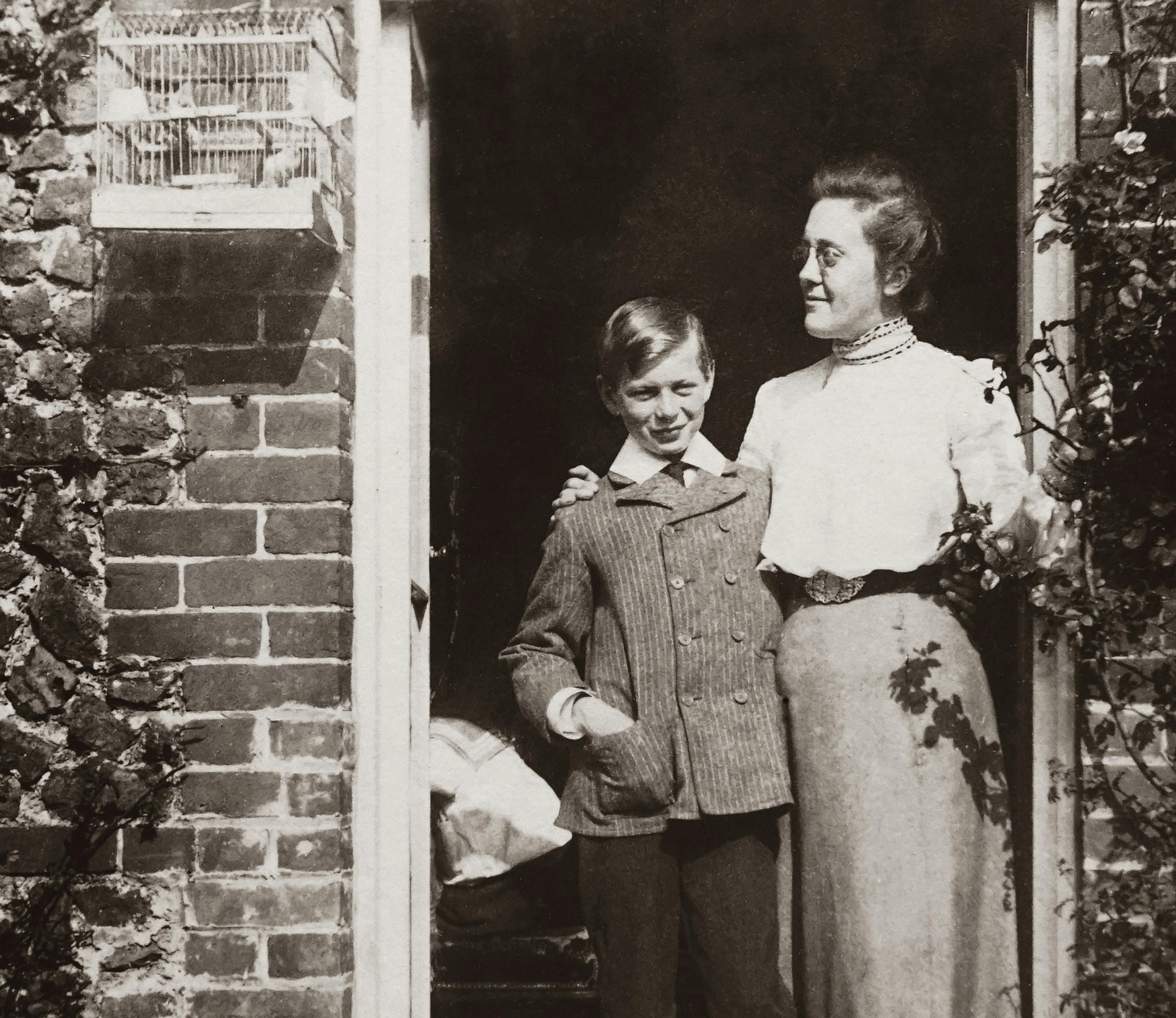 Black And White Photo Of Mother and Son Standing By The Doorway