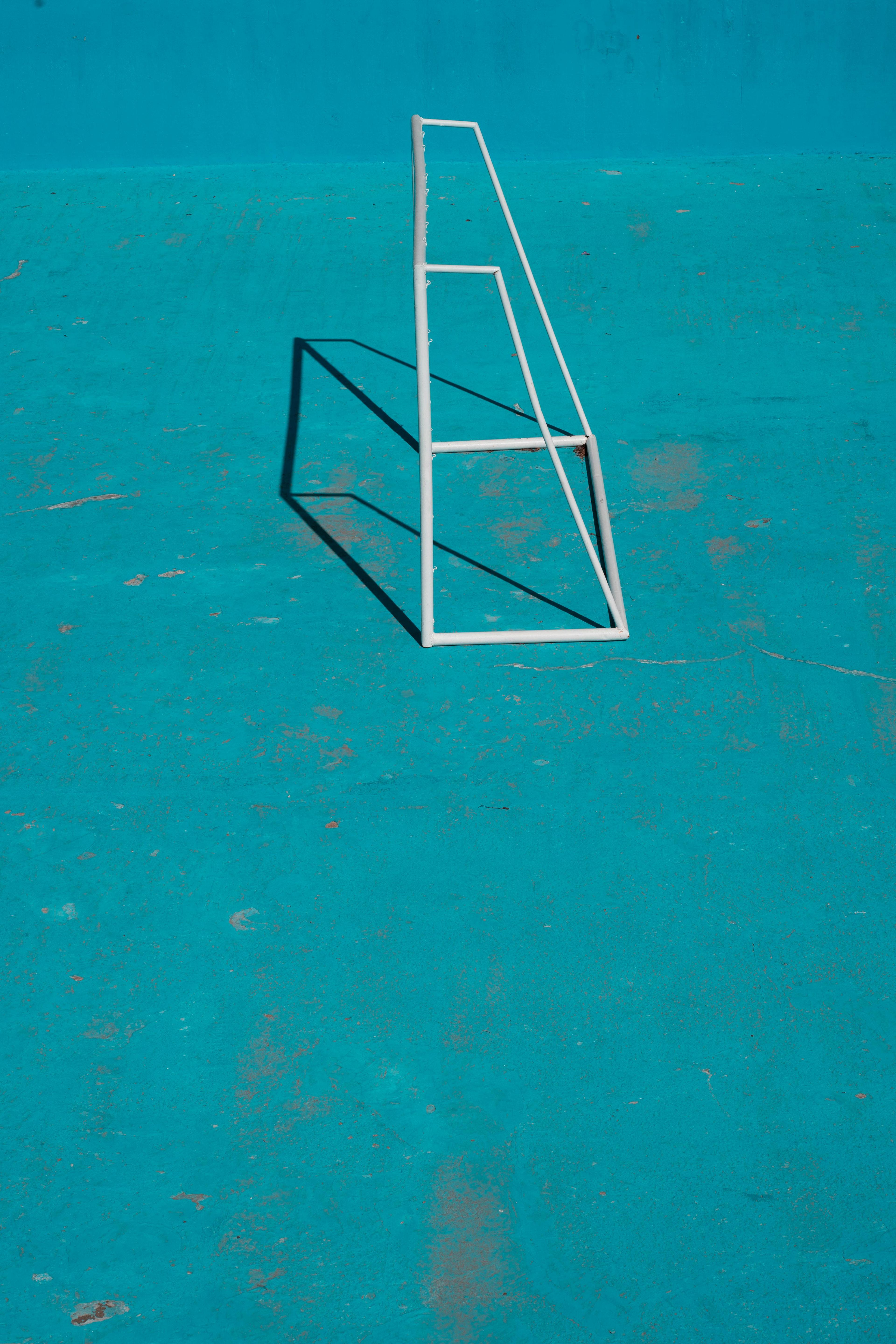 An abstract image featuring a geometric shadow on a turquoise surface, highlighting minimalism.