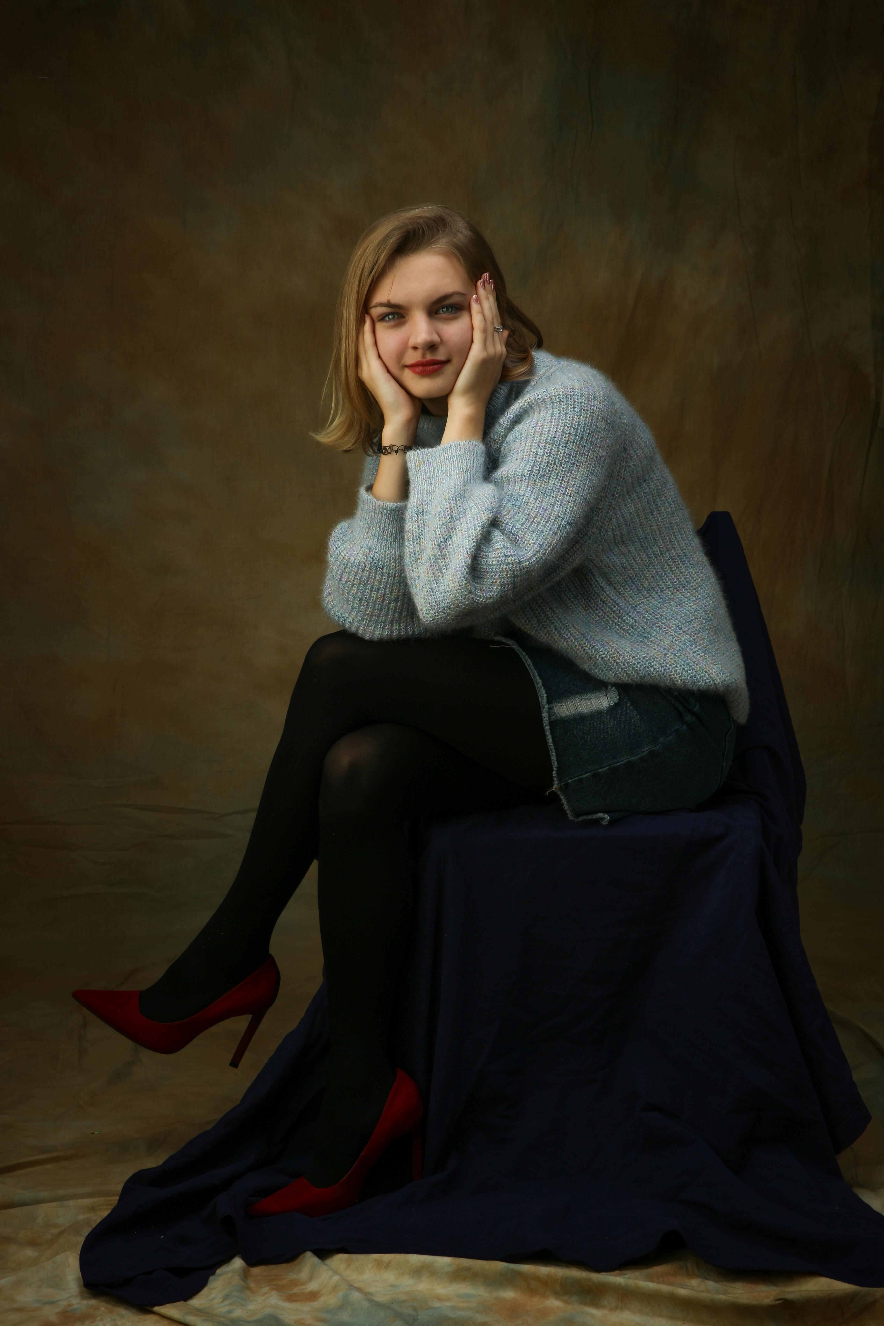 Elegant portrait of a young woman in fashionable knitwear, posing with confidence indoors.