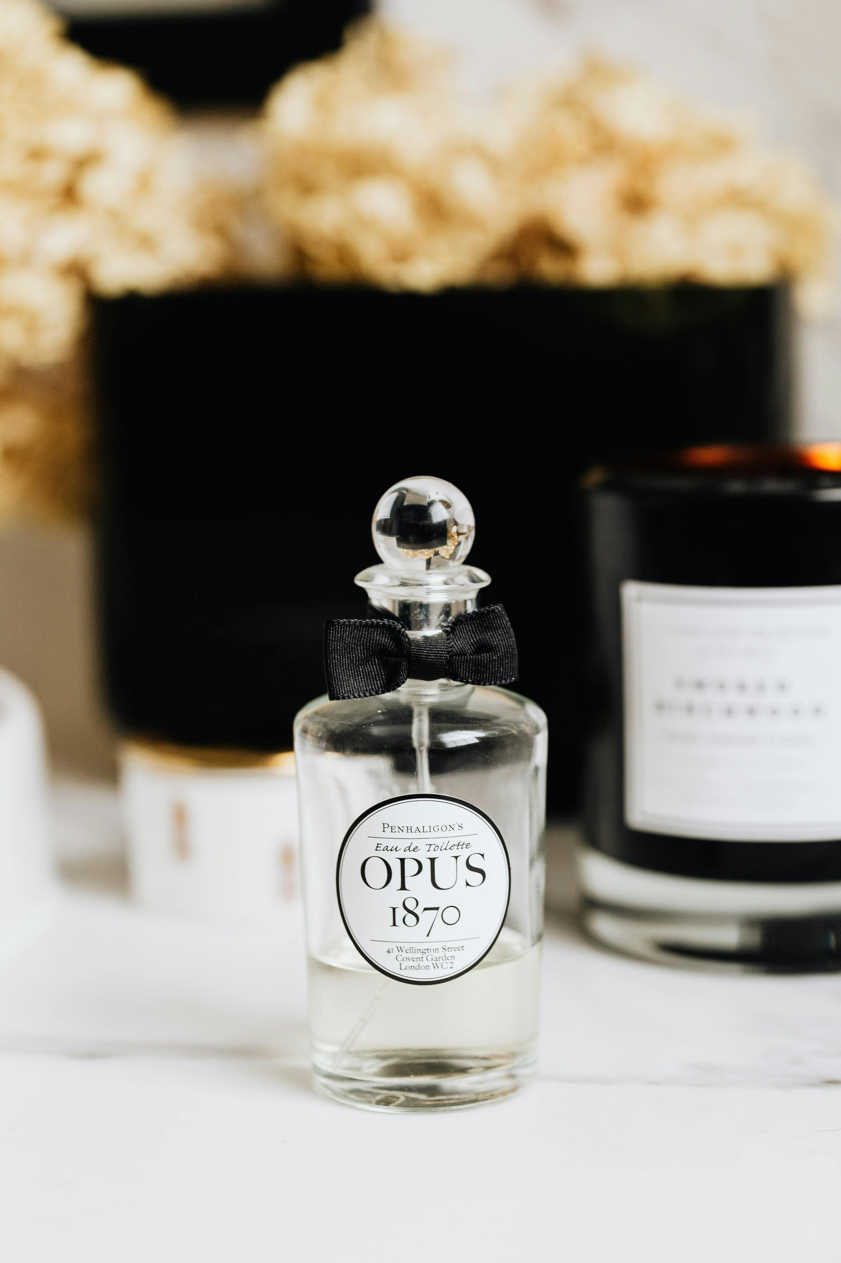 A luxurious still life featuring a clear glass perfume bottle with a ribbon, evoking elegance.