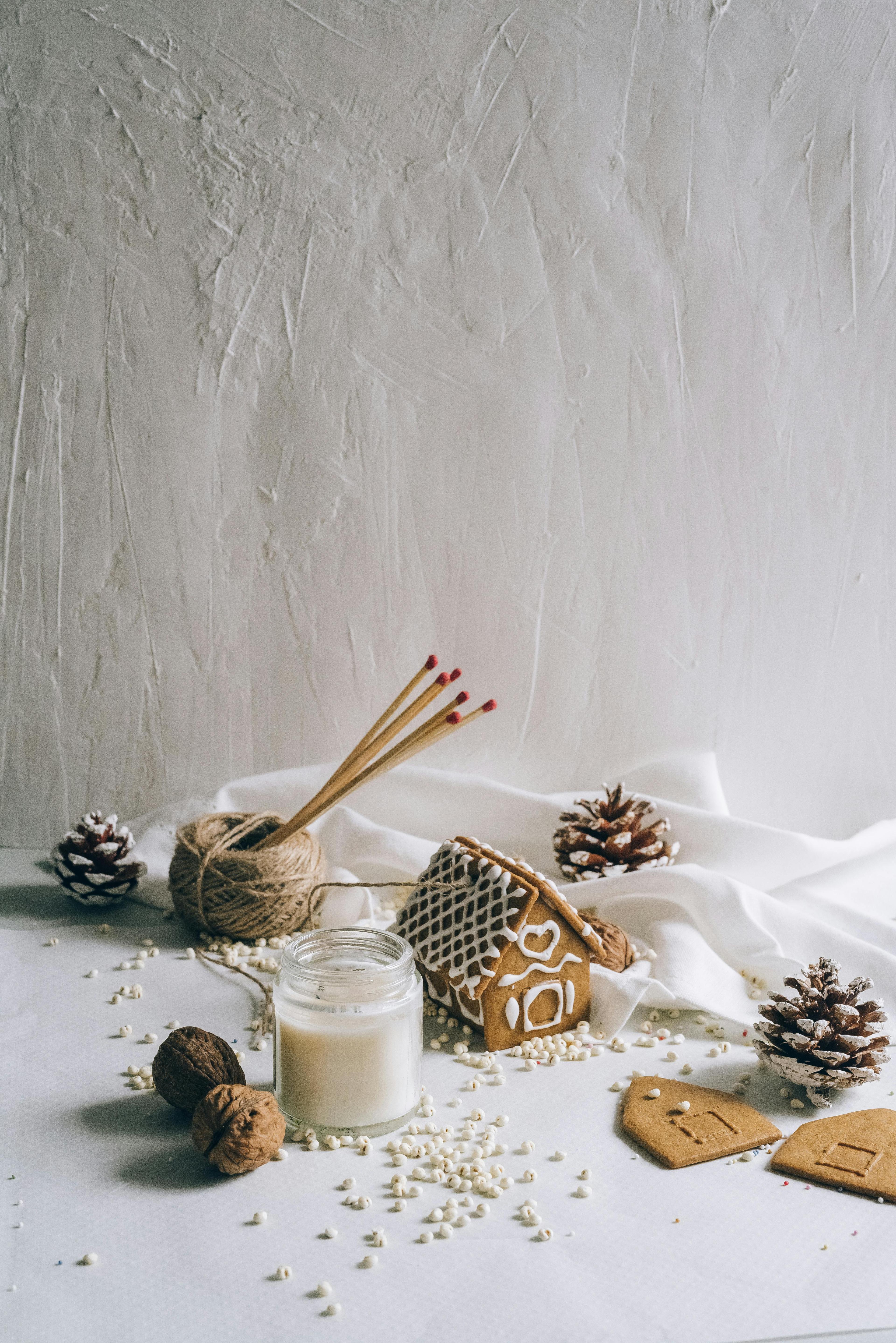 Cozy gingerbread house with pine cones and candle, perfect for holiday warmth.